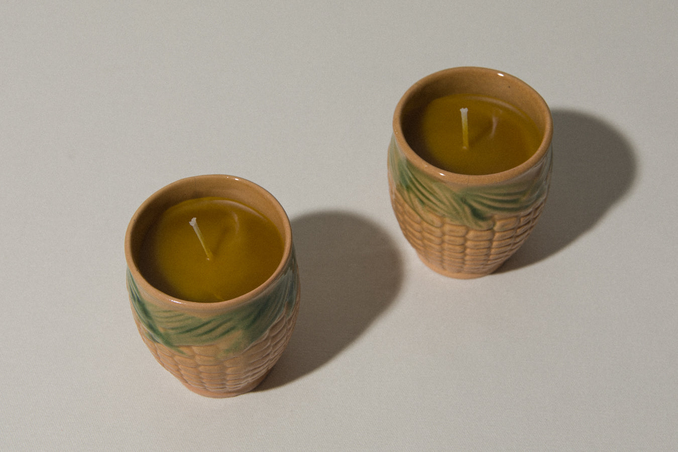 Set of two beeswax CANDLE in corn-motif faience holder