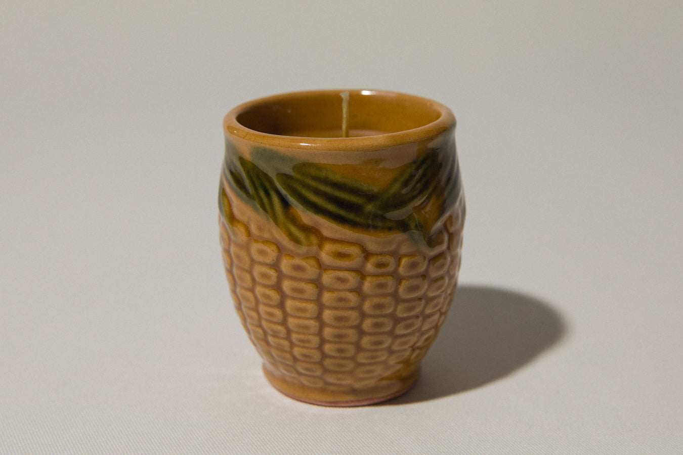 Set of three beeswax CANDLE in corn-motif faience holder