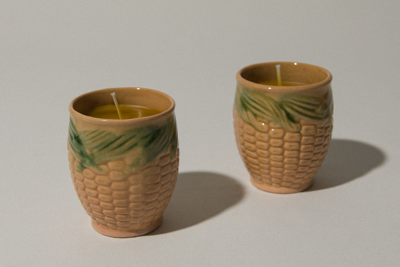 Set of two beeswax CANDLE in corn-motif faience holder