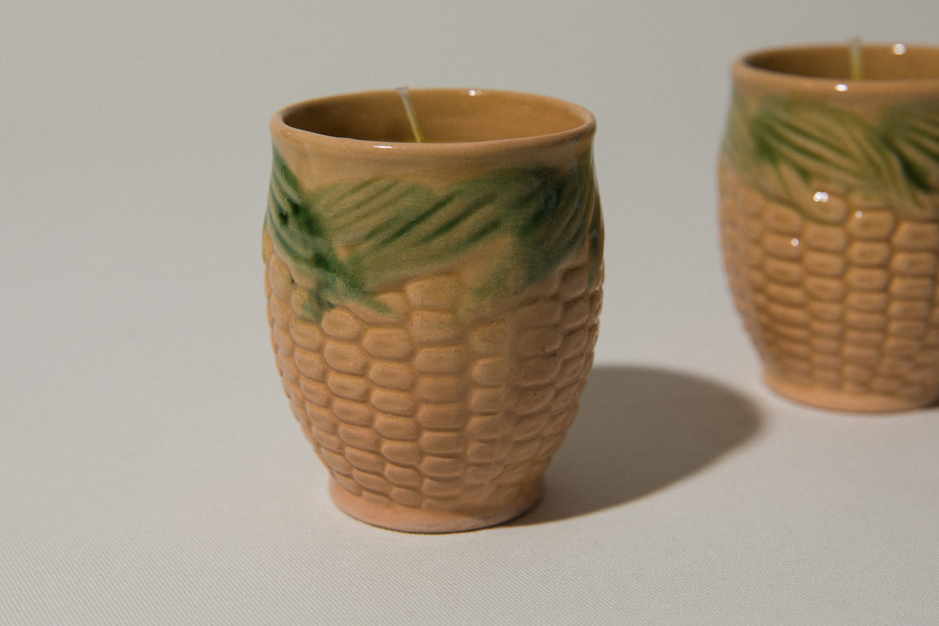 Set of two beeswax CANDLE in corn-motif faience holder