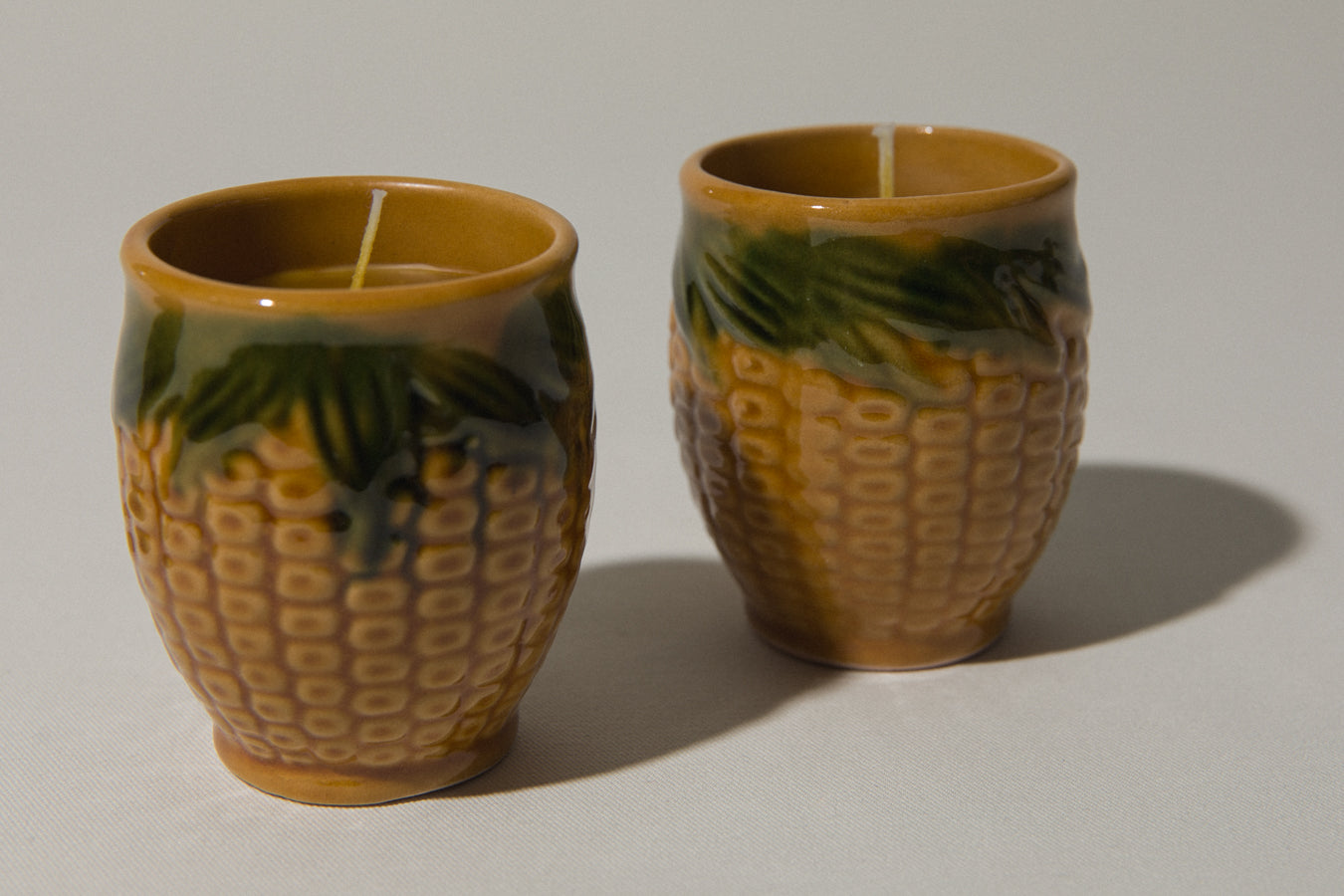 Set of three beeswax CANDLE in corn-motif faience holder